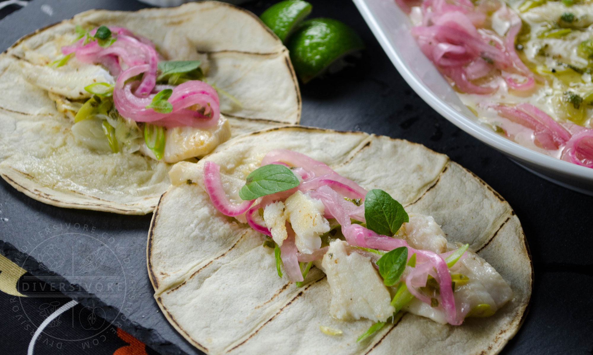 Pescado con vino - fish with white wine, cooked in a Mexican style, served in tacos with wine-pickled onions on a slate board