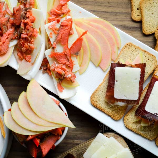 Pink Pearl apples and a charcuterie board with manchego, bison bresaola, smoked salmon, and endive