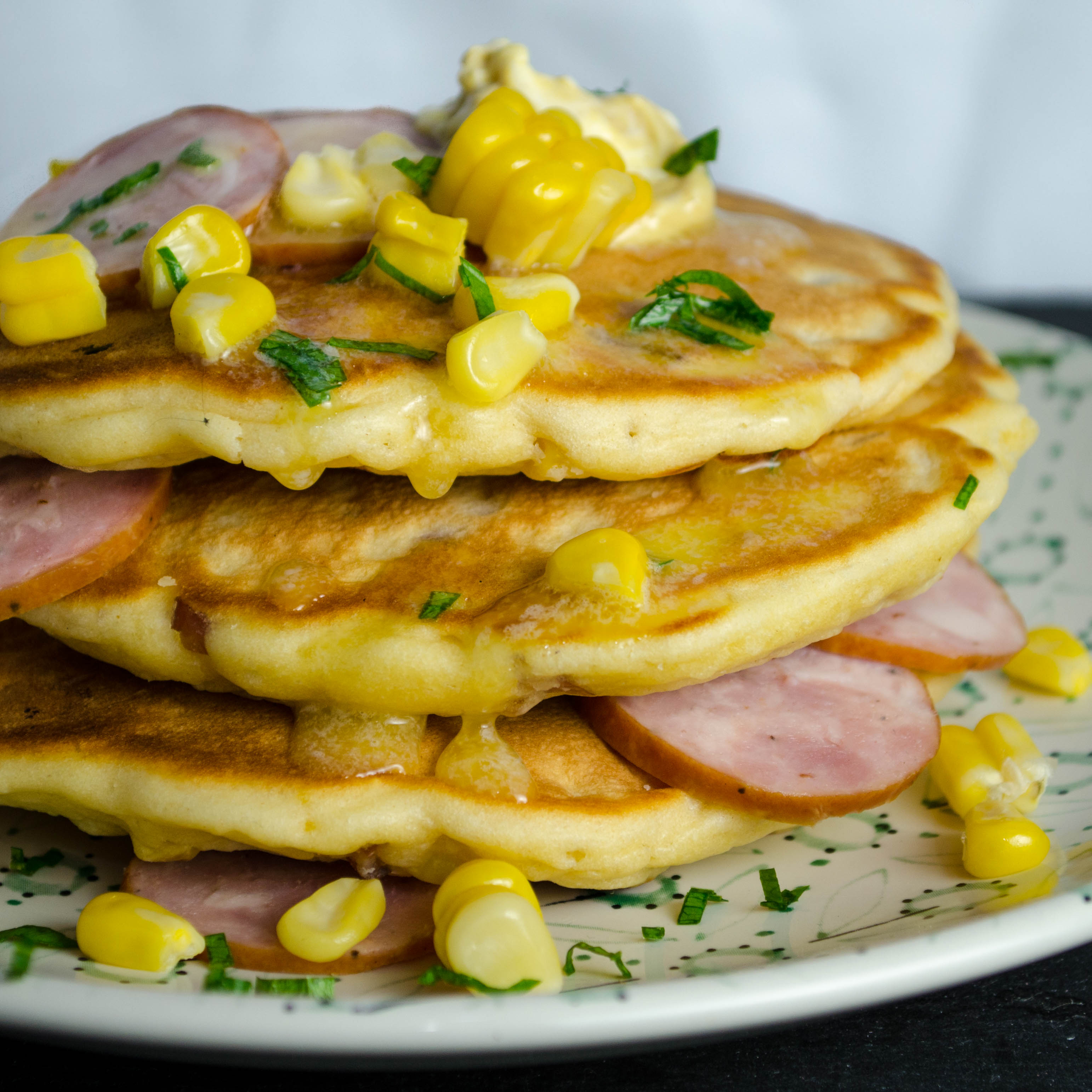 Savory pancakes with kielbasa and corn on a floral patterned plate