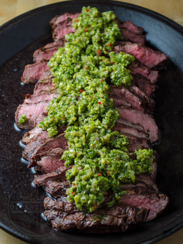 Garlic scape chimichurri on top of sliced steak