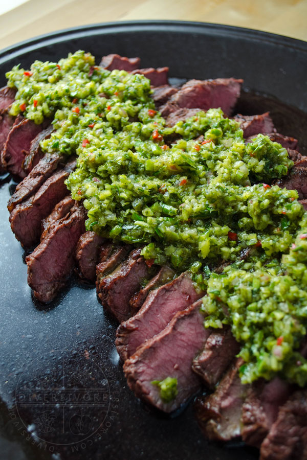 Garlic scape chimichurri on top of sliced steak