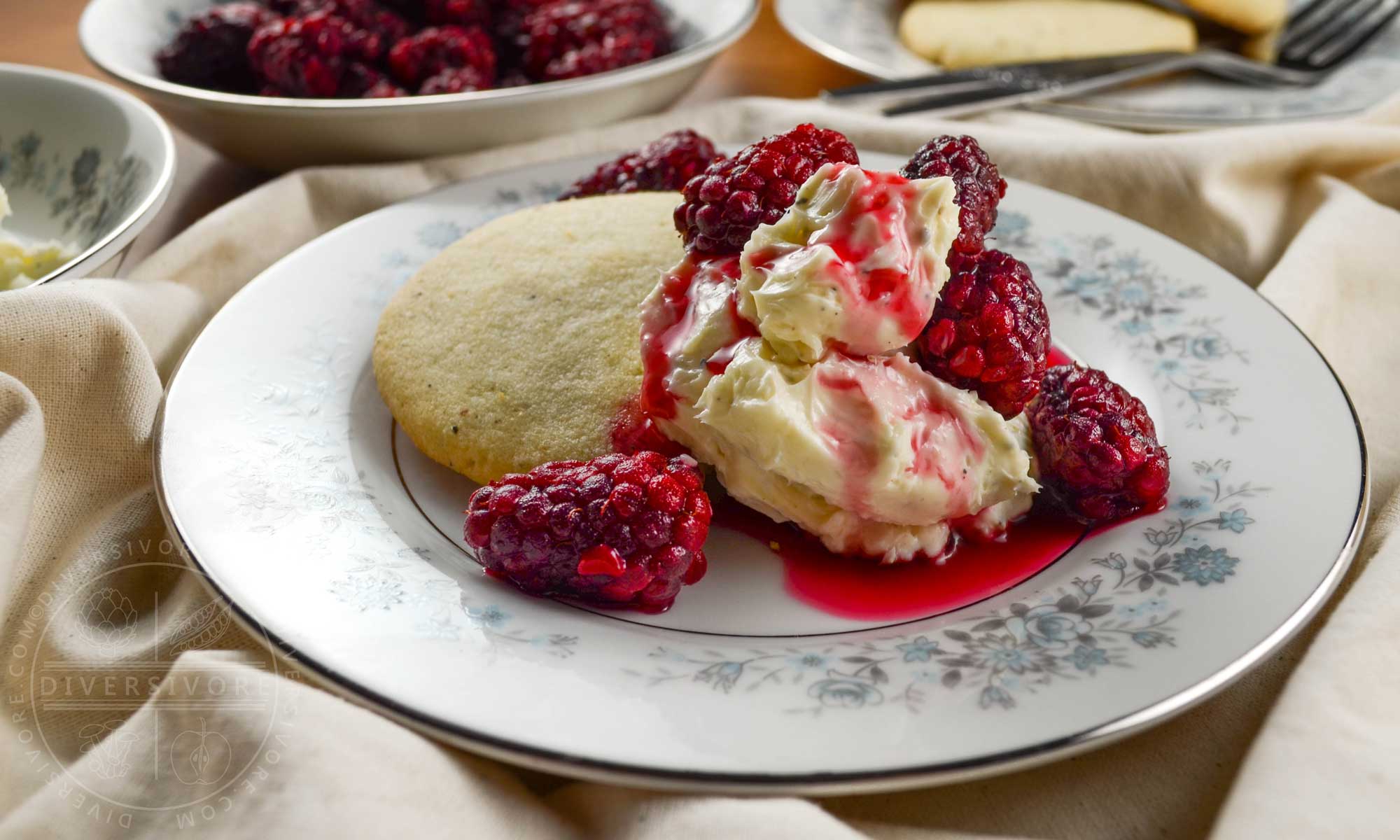 Pepper shortbread cookies with tayberries and sweet cream cheese on a small floral patterned plate