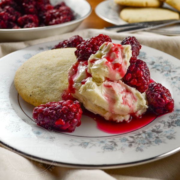 Pepper shortbread cookies with tayberries and sweet cream cheese on a small floral patterned plate