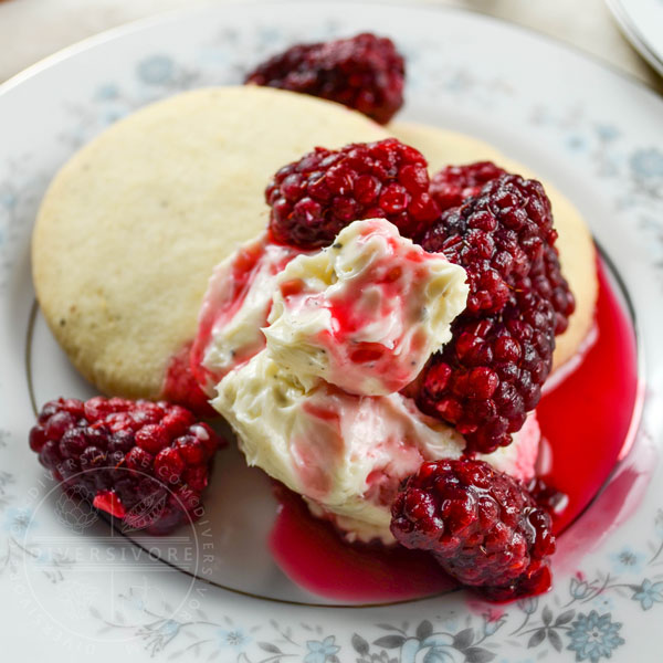 Pepper shortbread cookies with tayberries and sweet cream cheese on a small floral patterned plate