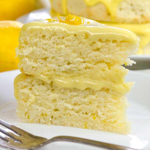 A slice of Lemon Whip Cake with Dairy-Free Lemon Curd served on a white plate with a fork