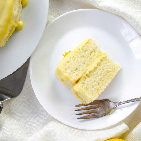 Overhead shot of a slice of Lemon Whip Cake with Dairy-Free Lemon Curd served on a white plate