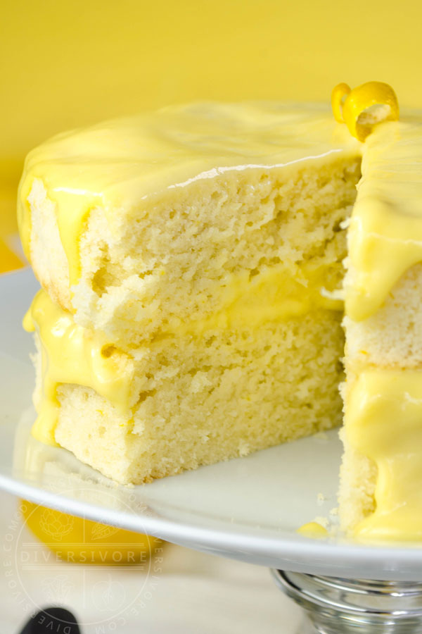 Lemon Whip Cake with Dairy-Free Lemon Curd on a cake plate, showing one slice removed