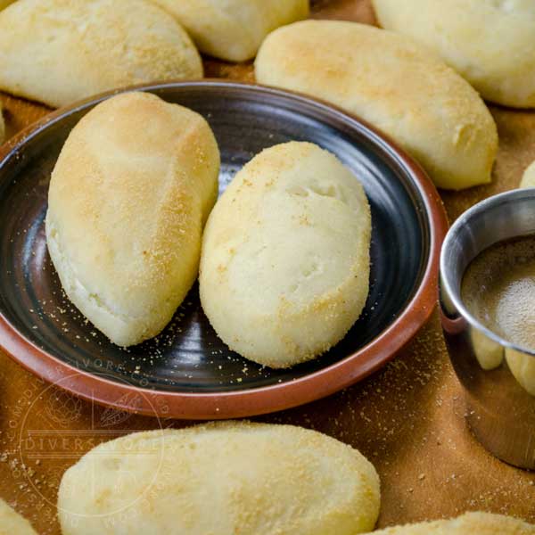 Pandesal (Filipino rolls) on a plate with a small cup of espresso