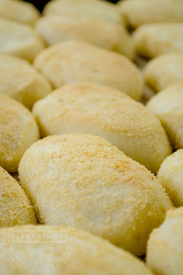 A line of pandesal buns on a baking tray
