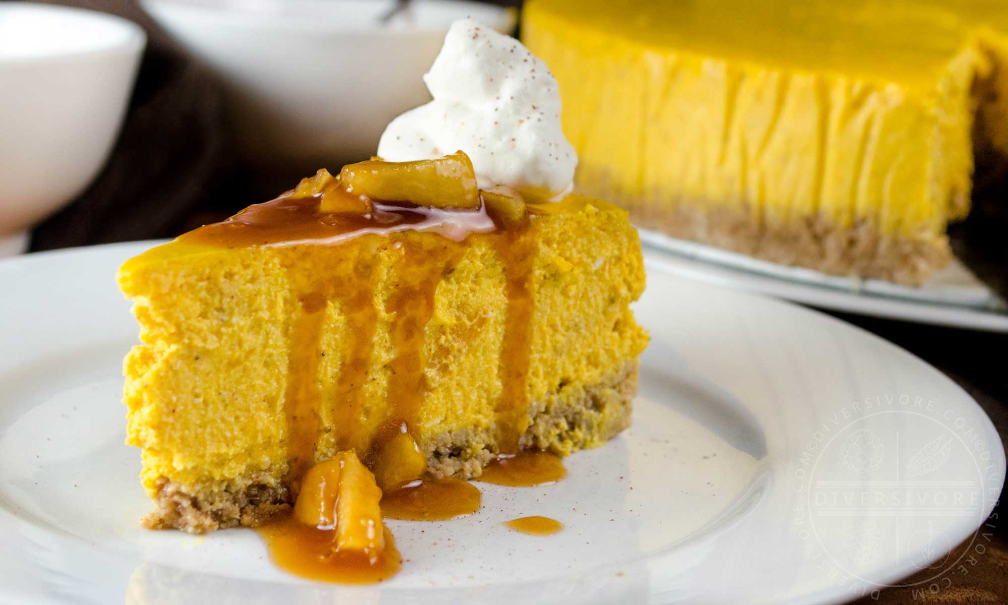 Pumpkin apple cheesecake with apple caramel sauce, whipped cream, and a gluten-free oat crust