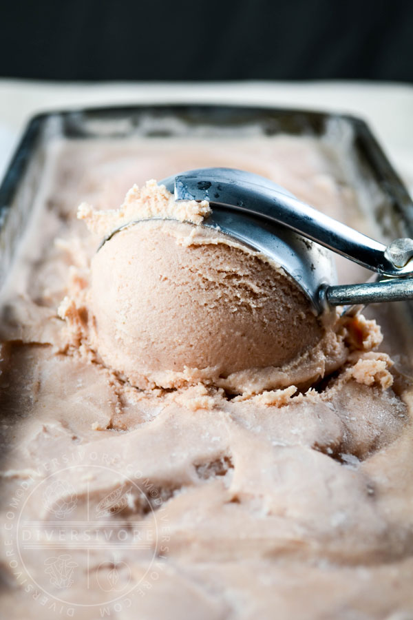 Cranberry chai ice cream being scooped from a container