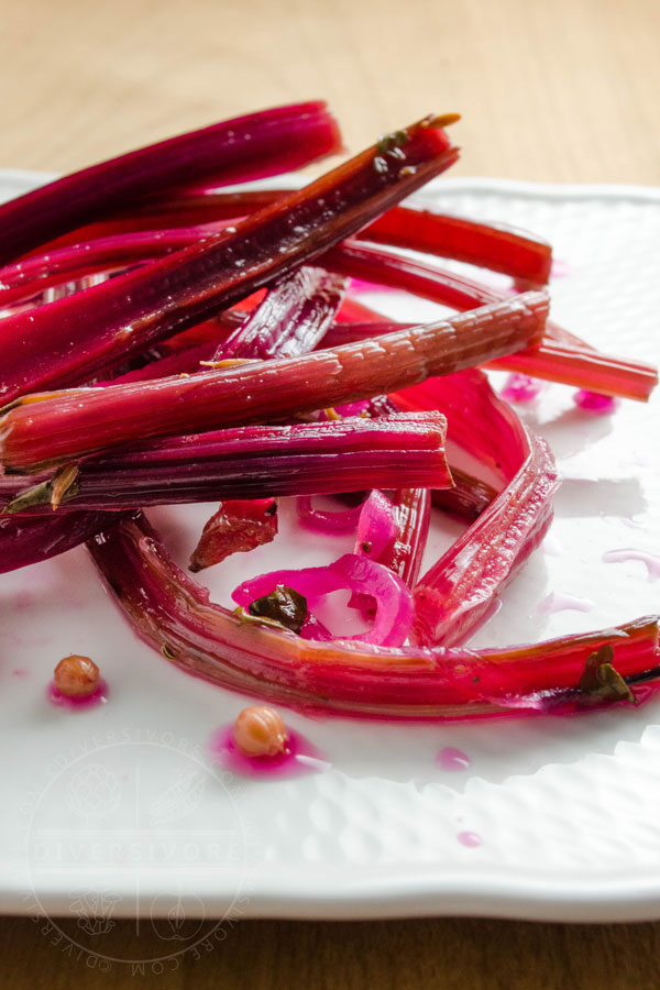 Spicy beet stem pickles on a white plate