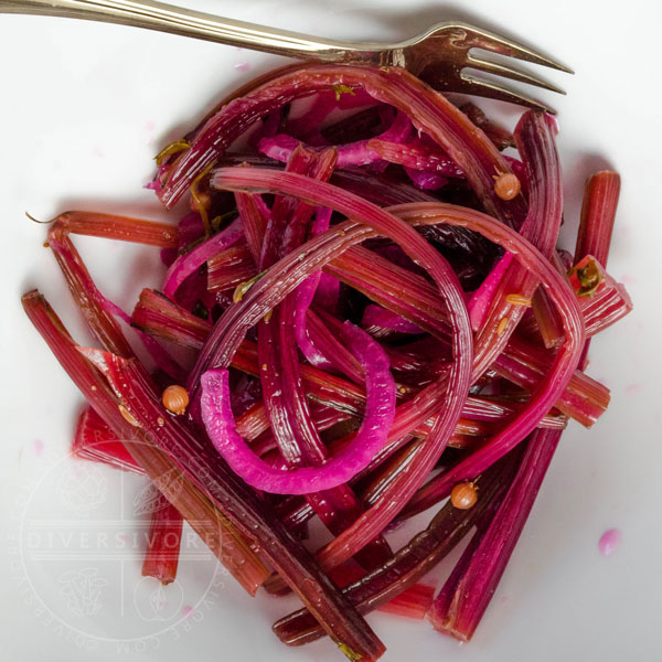 Spicy beet stem pickles in a white bowl