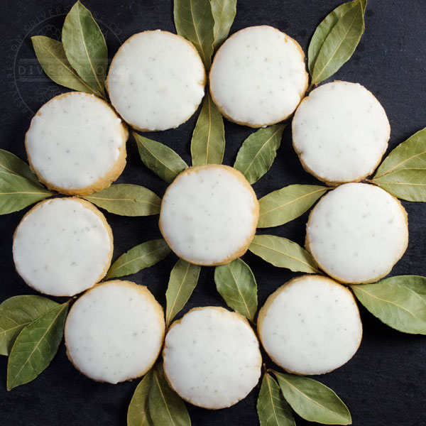 Bayleaf and lemon shortbread arranged in a decorative wreath-like circle, surrounded by bay leaves