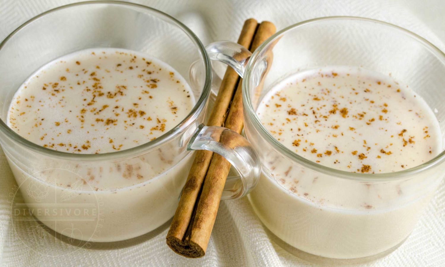 Coquito - Puerto Rican Eggnog - served in glass mugs with a cinnamon stick