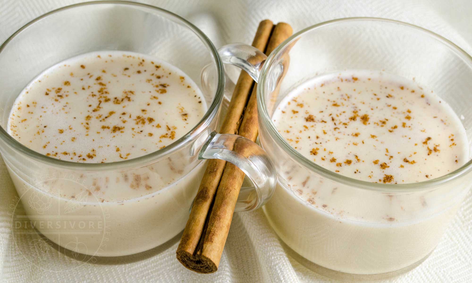 Coquito (Puerto Rican coconut eggnog) in glass mugs with a cinnamon stick