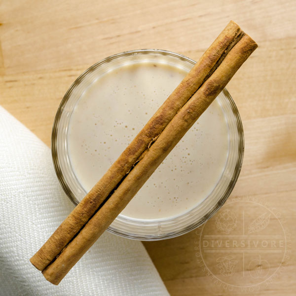 Coquito with cinnamon in a small glass tumbler