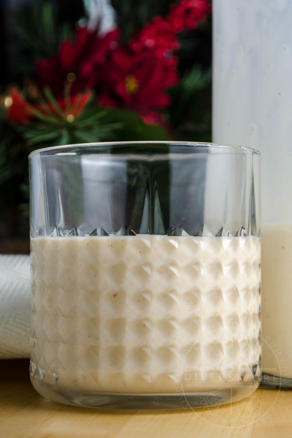 Coquito in a glass and a bottle with Christmas decorations