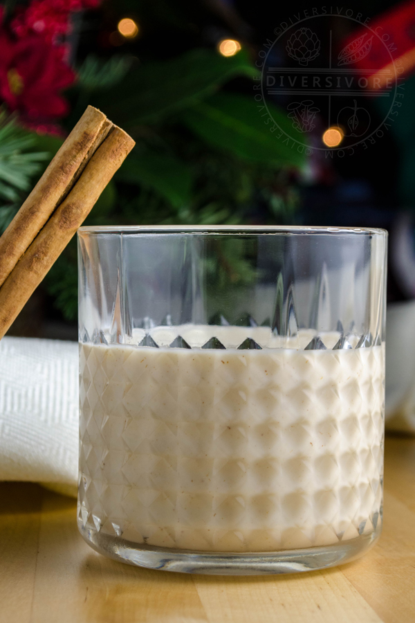 Coquito with cinnamon in a small glass tumbler