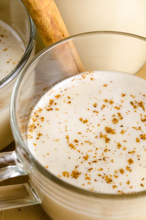 Coquito with cinnamon in a small glass mug