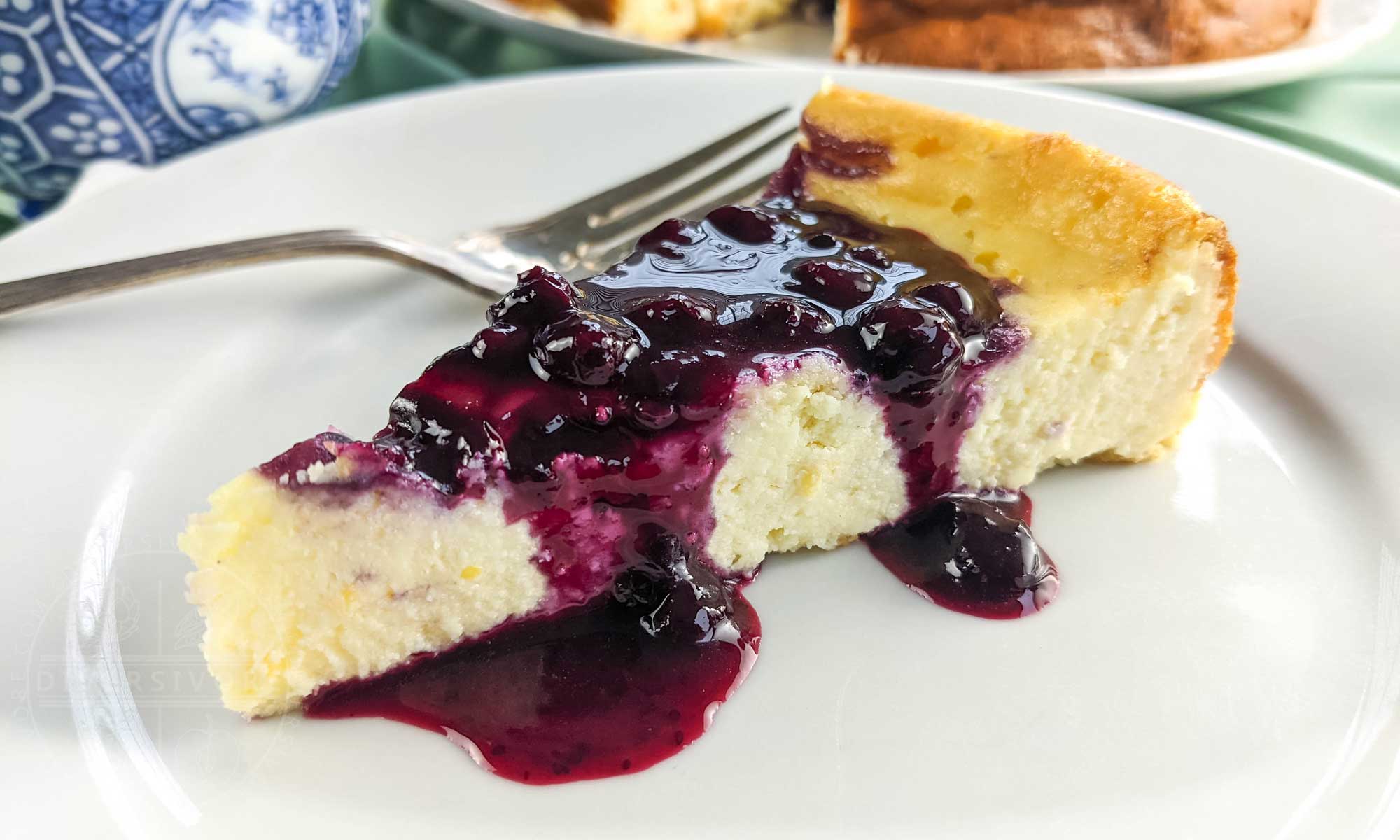 A slice of ricotta cheesecake with blueberry and lemon sauce