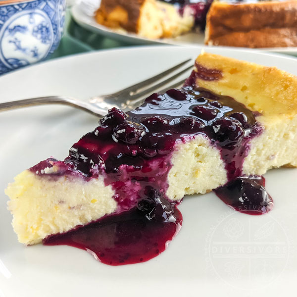 A slice of ricotta cheesecake with blueberry and lemon sauce