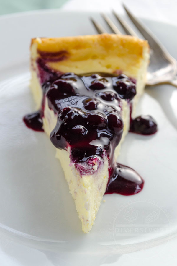 A slice of ricotta cheesecake with blueberry and lemon sauce