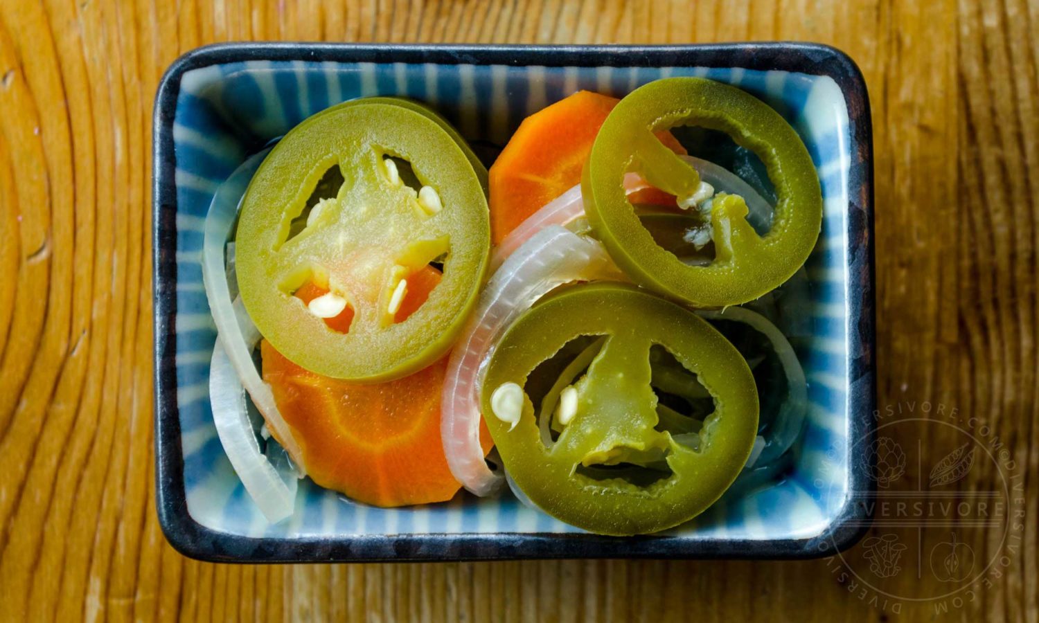 Chiles en escabeche - Mexican pickled carrots and jalapeños in a small dish